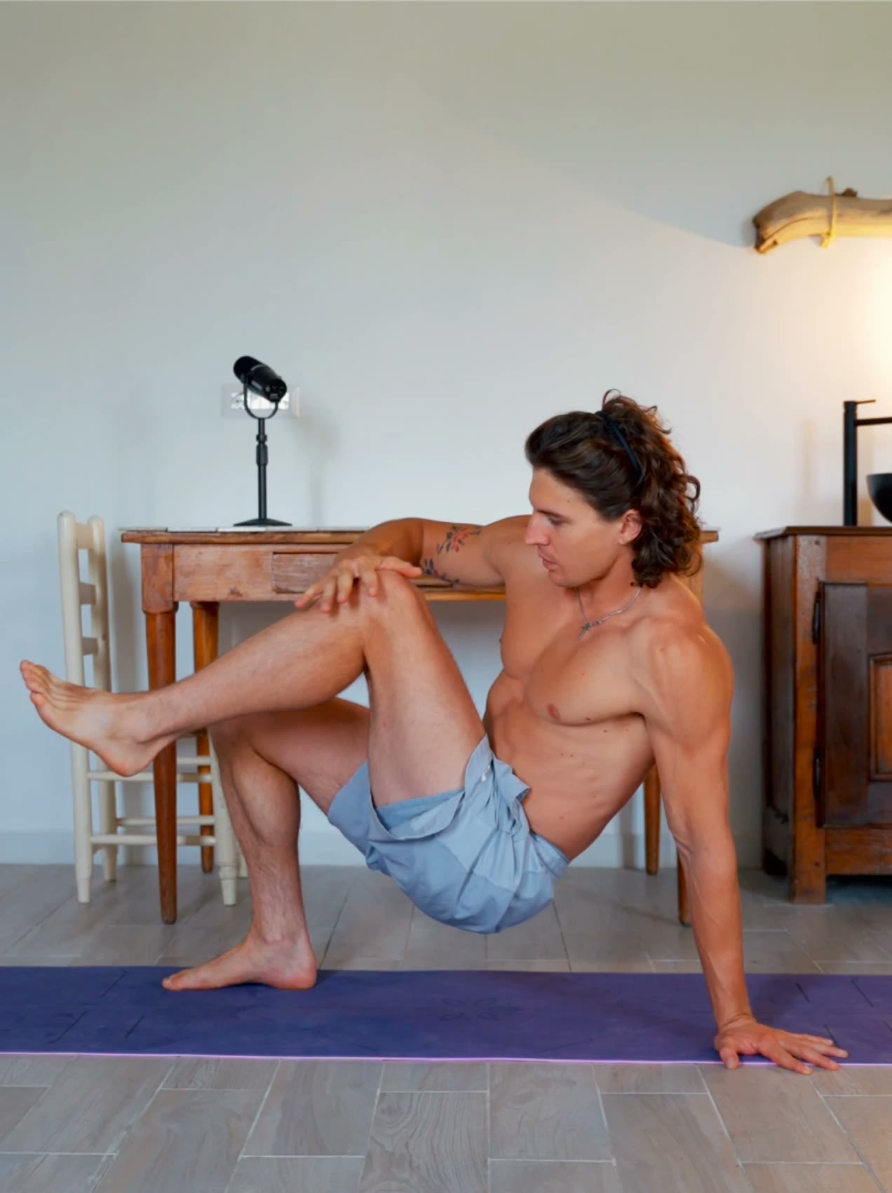 Genno in a seated V-hold, one leg extended